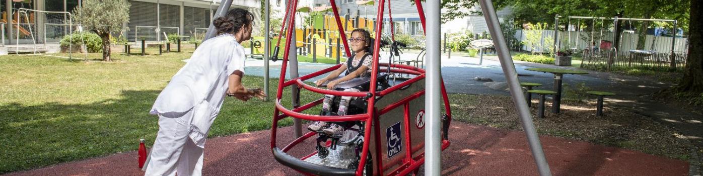 balançoire avec un enfant en fauteuil roulant